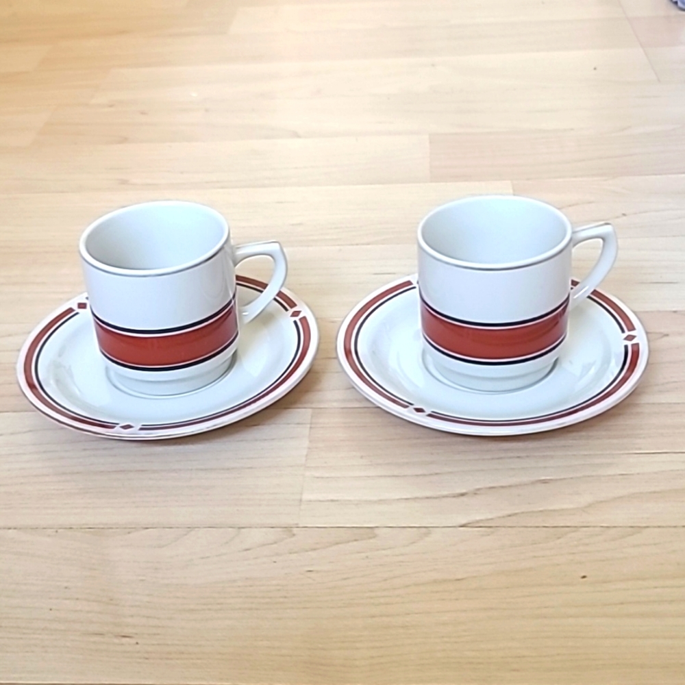 A set of 2 cups & saucers with red-maroon and black designs, and golden details